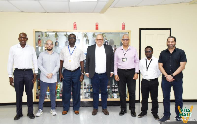 Mr. Michael Jensen (centre) pose with Mr. Gavin Todd,  Operations/Engineering Director, Sales and Marketing Executive Mr. Carlton Joao and other representatives of Banks DIH Limited and Royal Unibrew.
